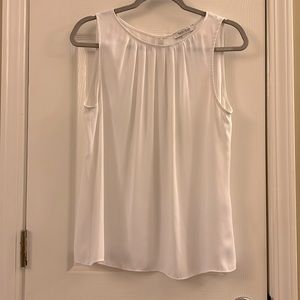 White sleeveless White House Black Market blouse. Pleats front neck button back